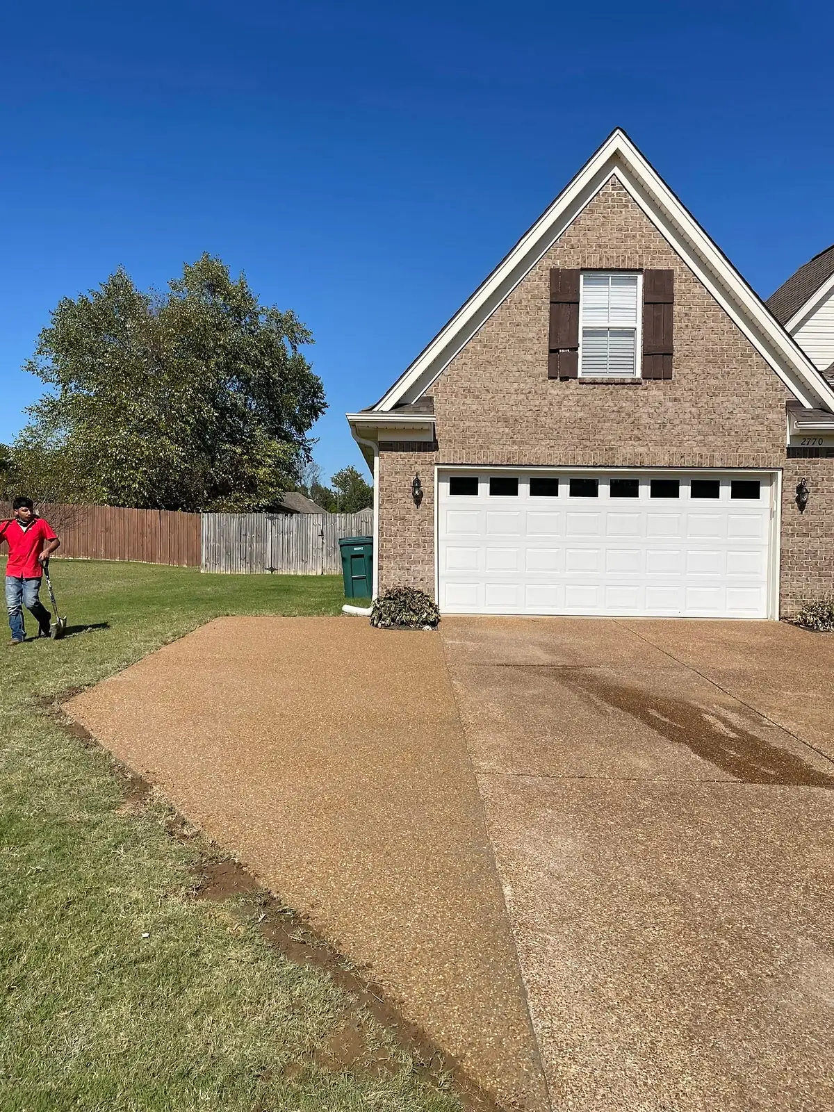 Crew member checking grade on a prepared driveway base