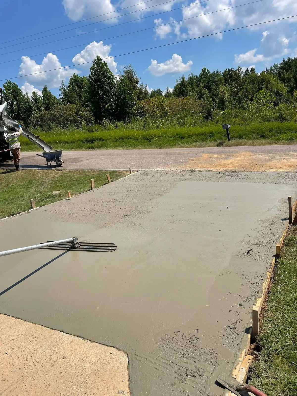 Wet concrete being screeded flat between timber forms