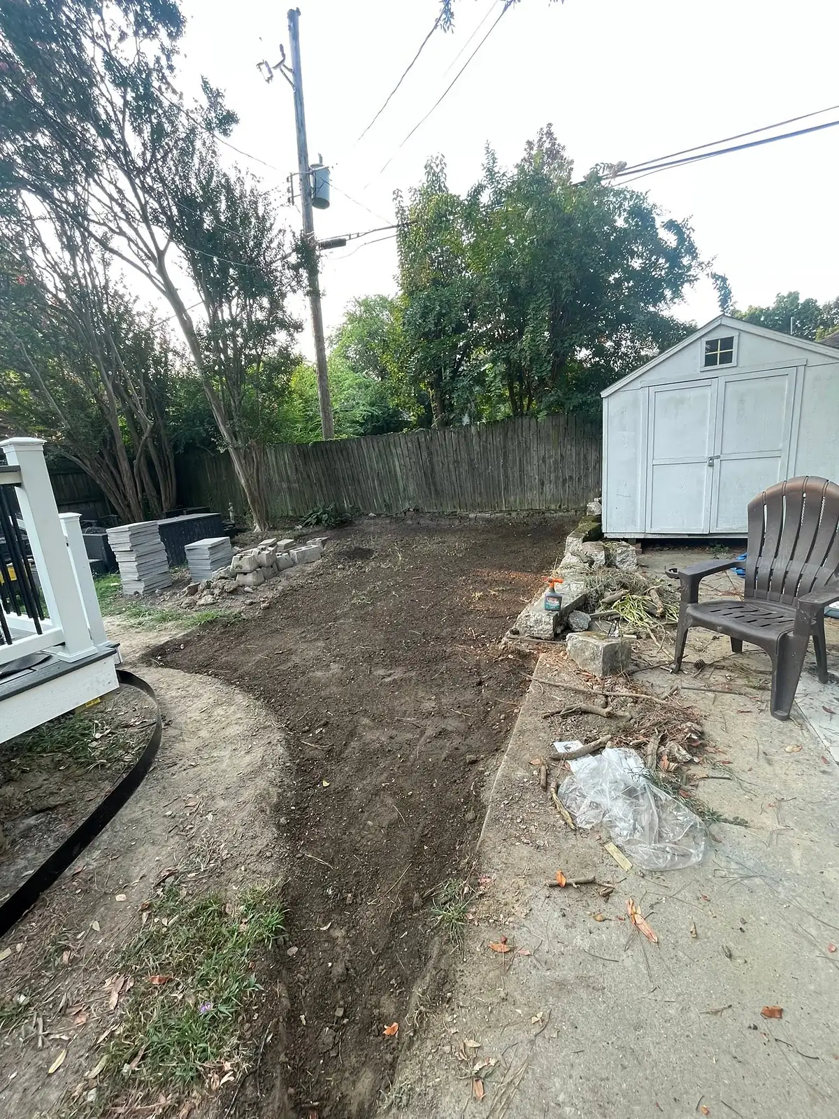 Bare muddy backyard with old broken concrete before the patio build