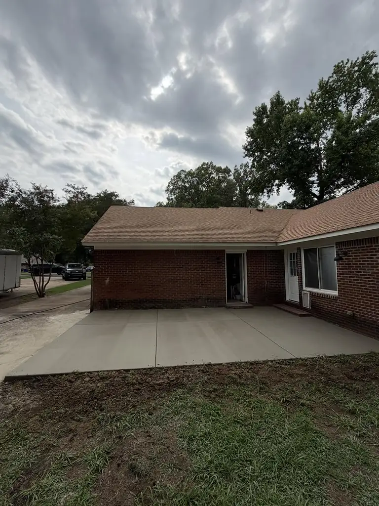 Finished broom-finish concrete driveway beside a red brick ranch home in Memphis