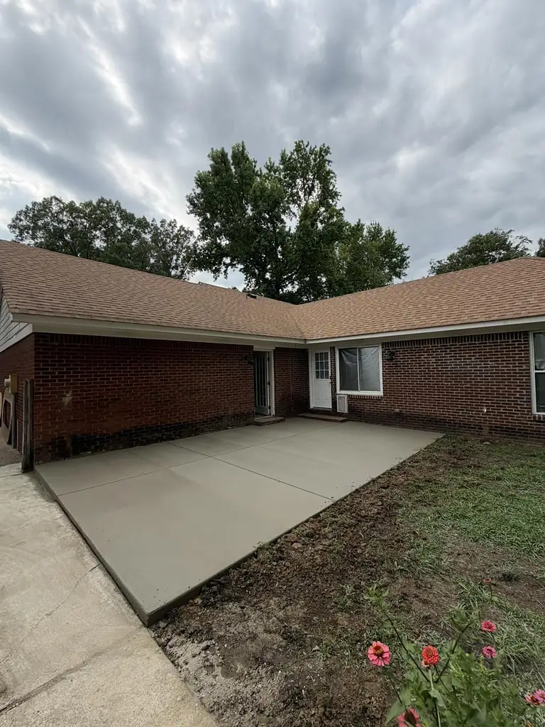 Wide angle of a newly poured concrete driveway running to the street