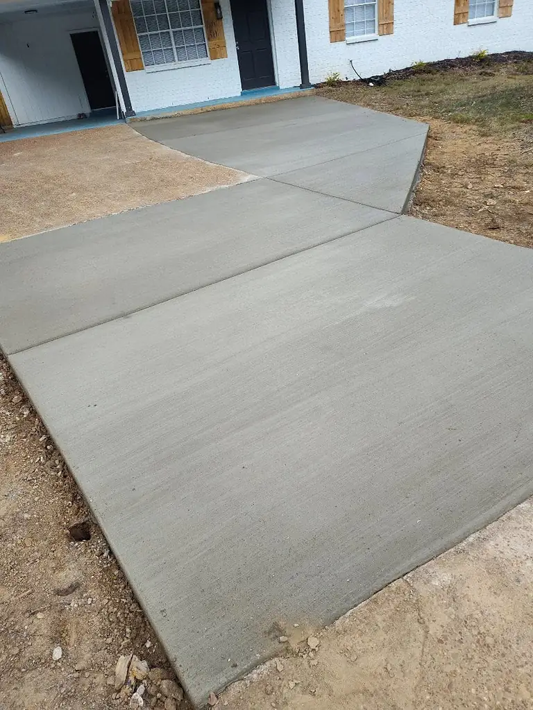 Smooth new concrete driveway with a crisp edge against the lawn