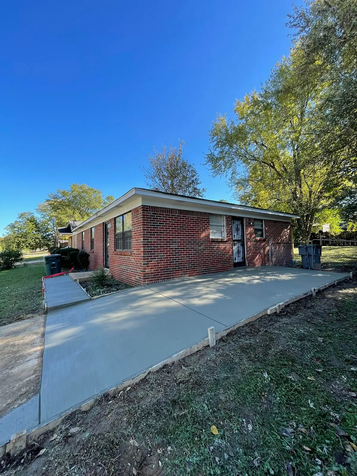 New driveway curving from a brick ranch house down to the road