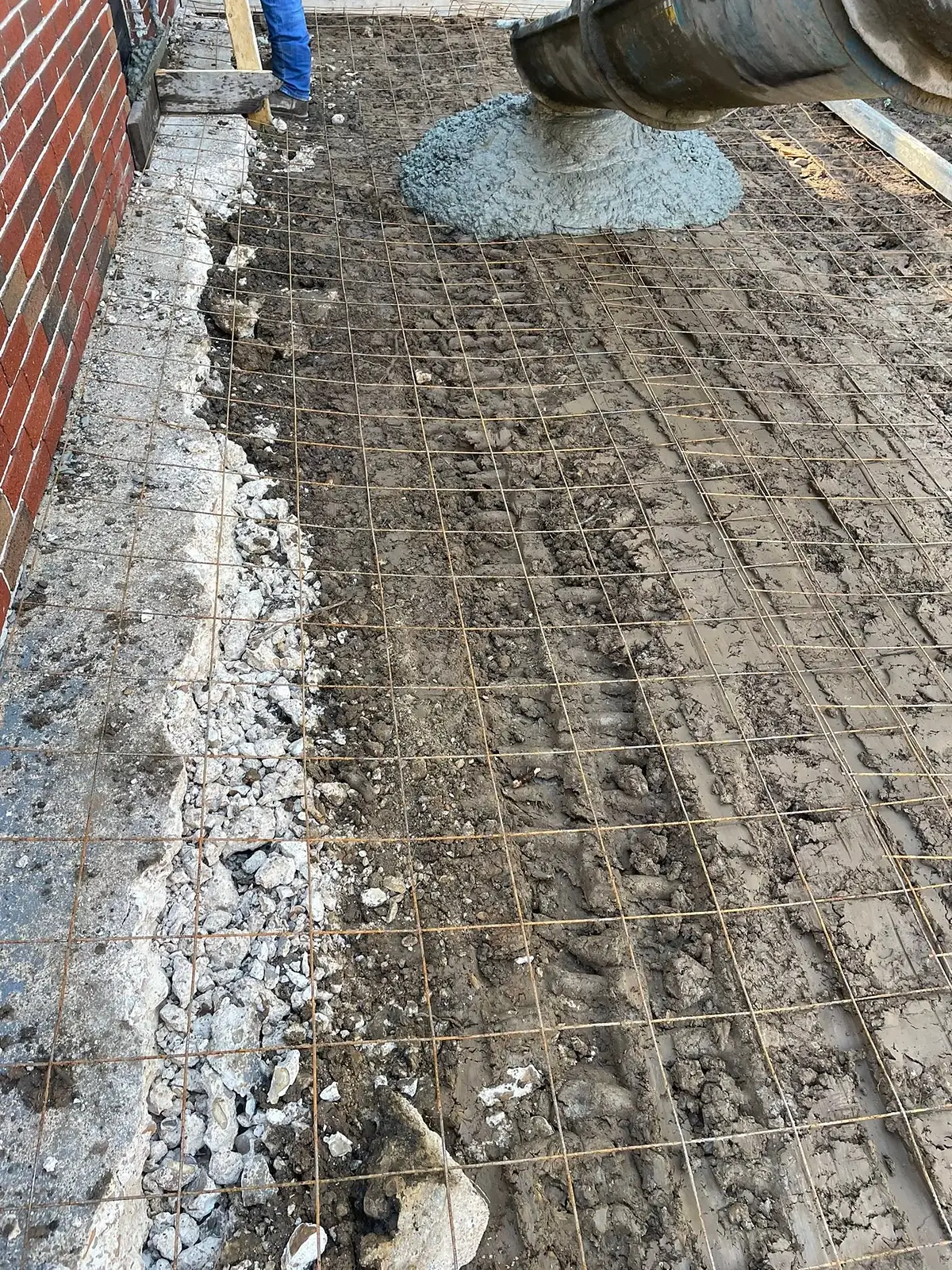 Wire mesh and rebar grid tied over a gravel base before the pour