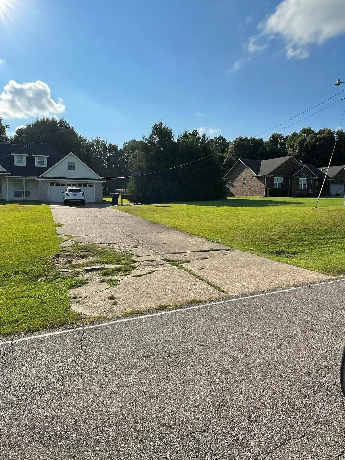 Cracked weed grown driveway before removal at a rural property