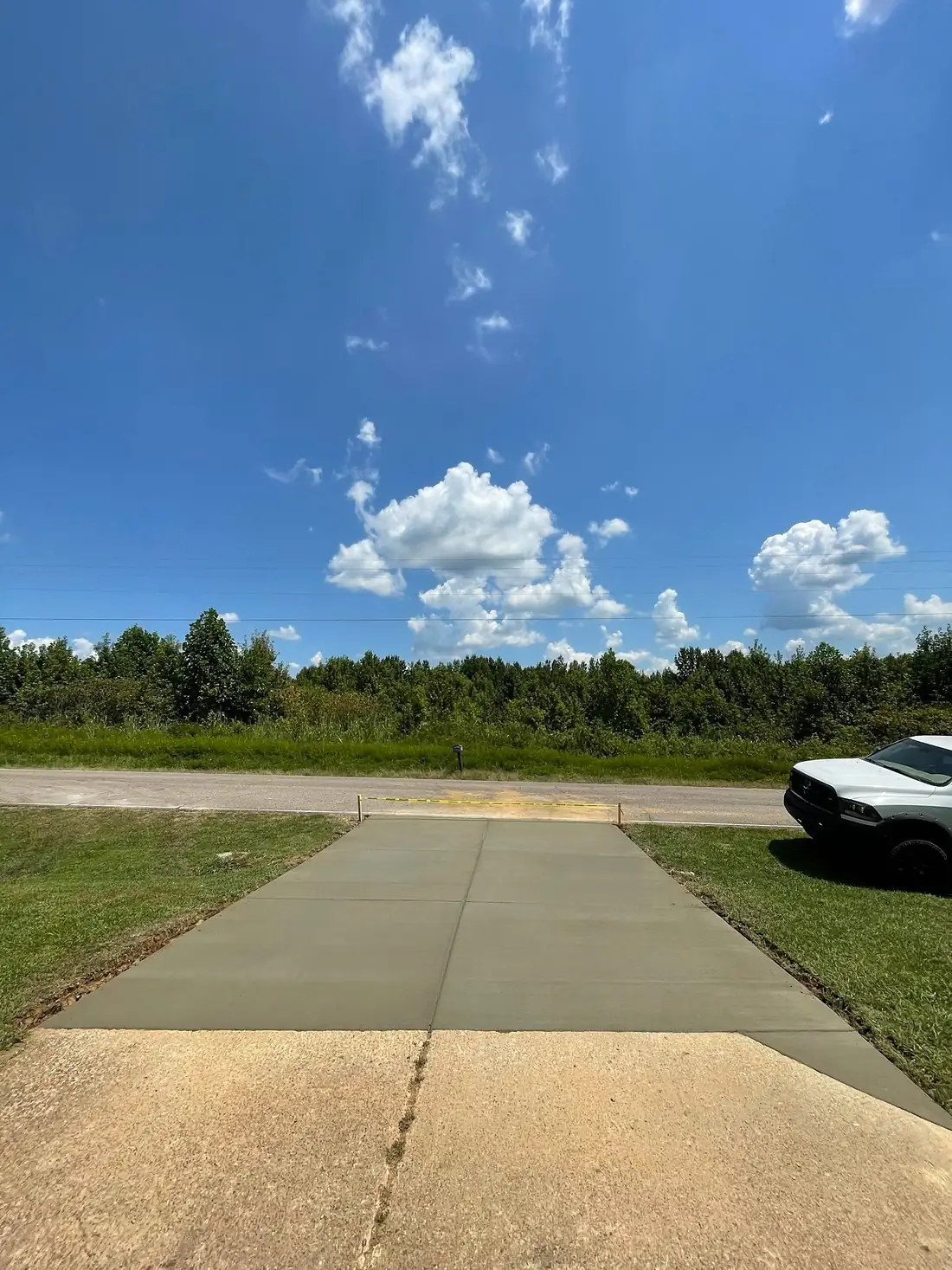 Fresh concrete driveway stretching toward the treeline