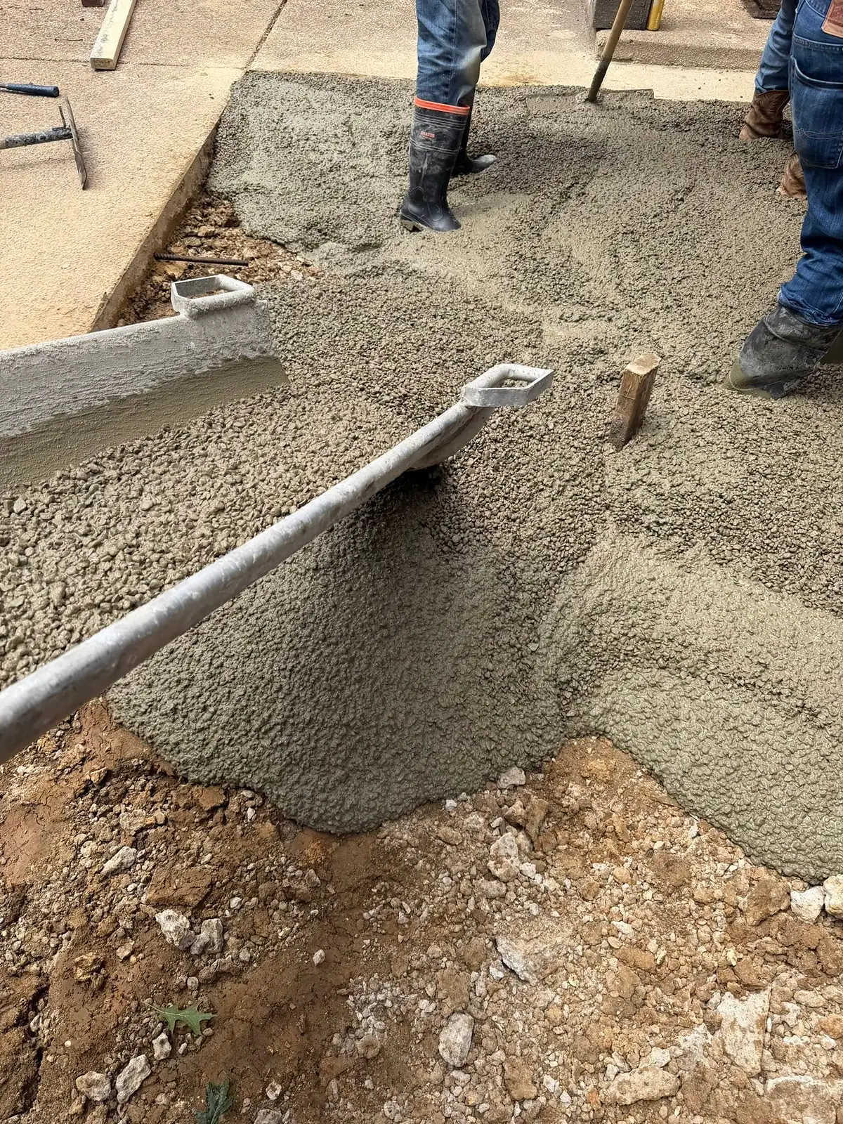Close up of wet concrete being screeded over rebar during a pour
