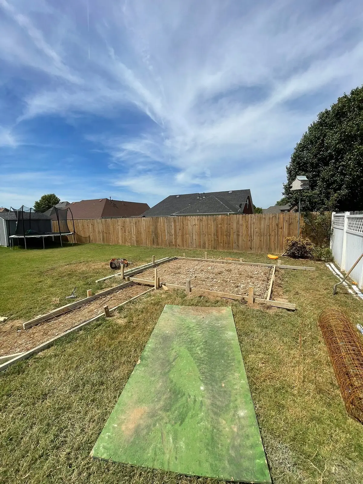 Timber forms staked across a lawn for a new backyard walkway