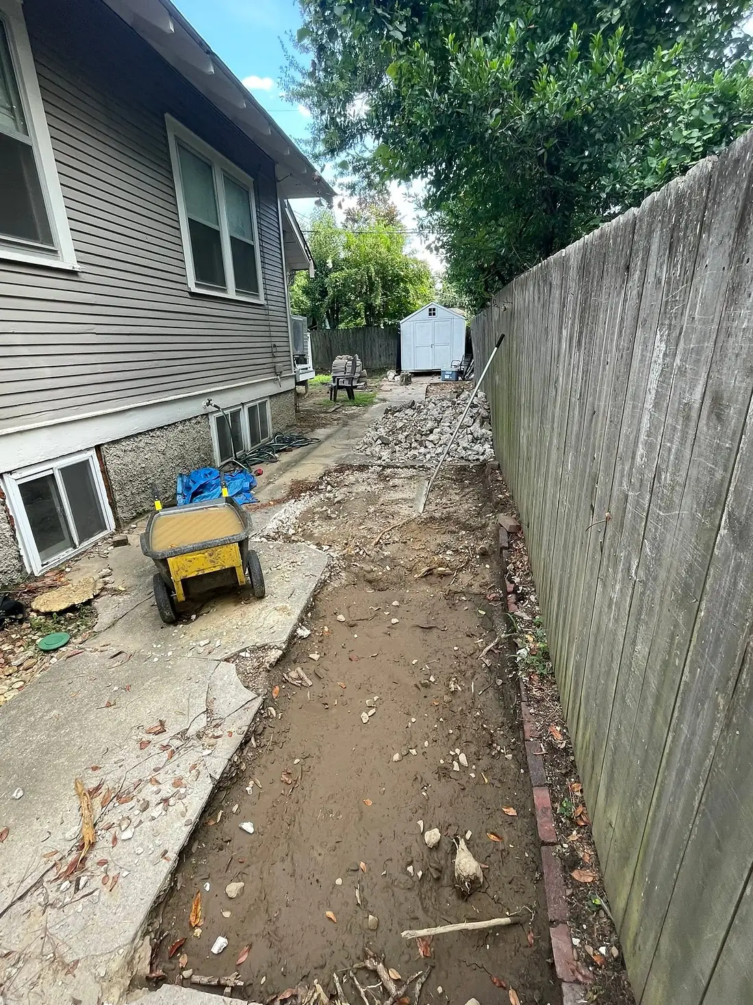 Side yard excavated down to soil with a power buggy standing by