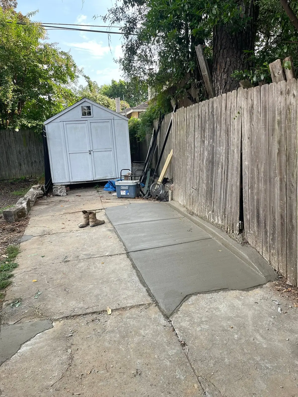 Finished side yard concrete path running to a backyard shed
