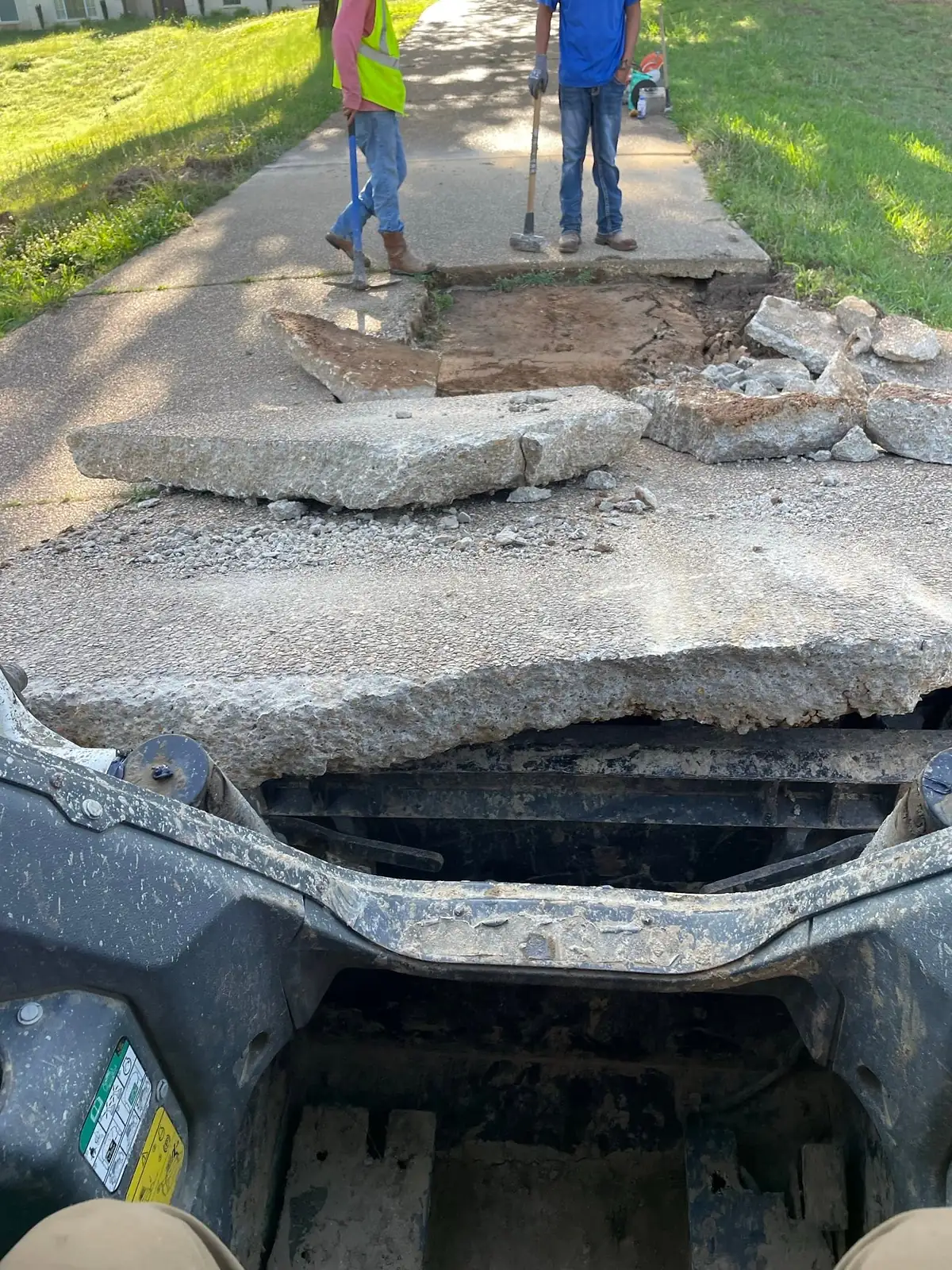 Thick broken concrete slabs lifted out by machine during tear out