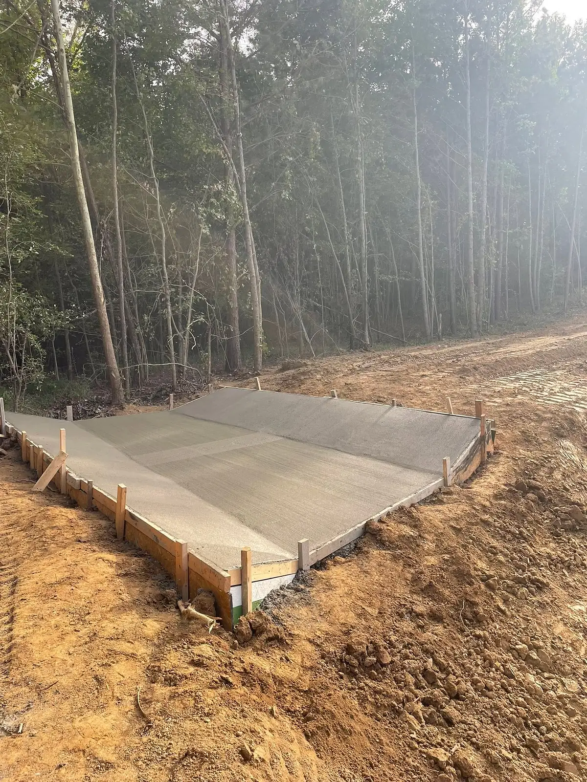 Large finished concrete slab poured on a cleared rural building site