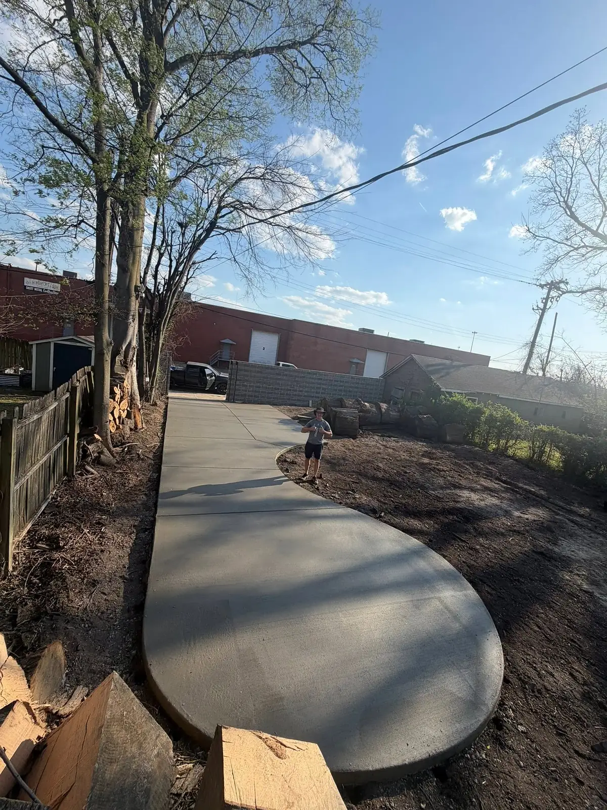 Curved concrete walkway with a rounded end poured through a back lot