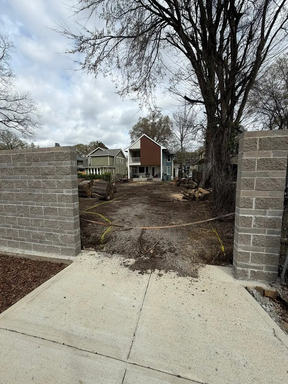 Finished concrete walkway passing between two block pillars