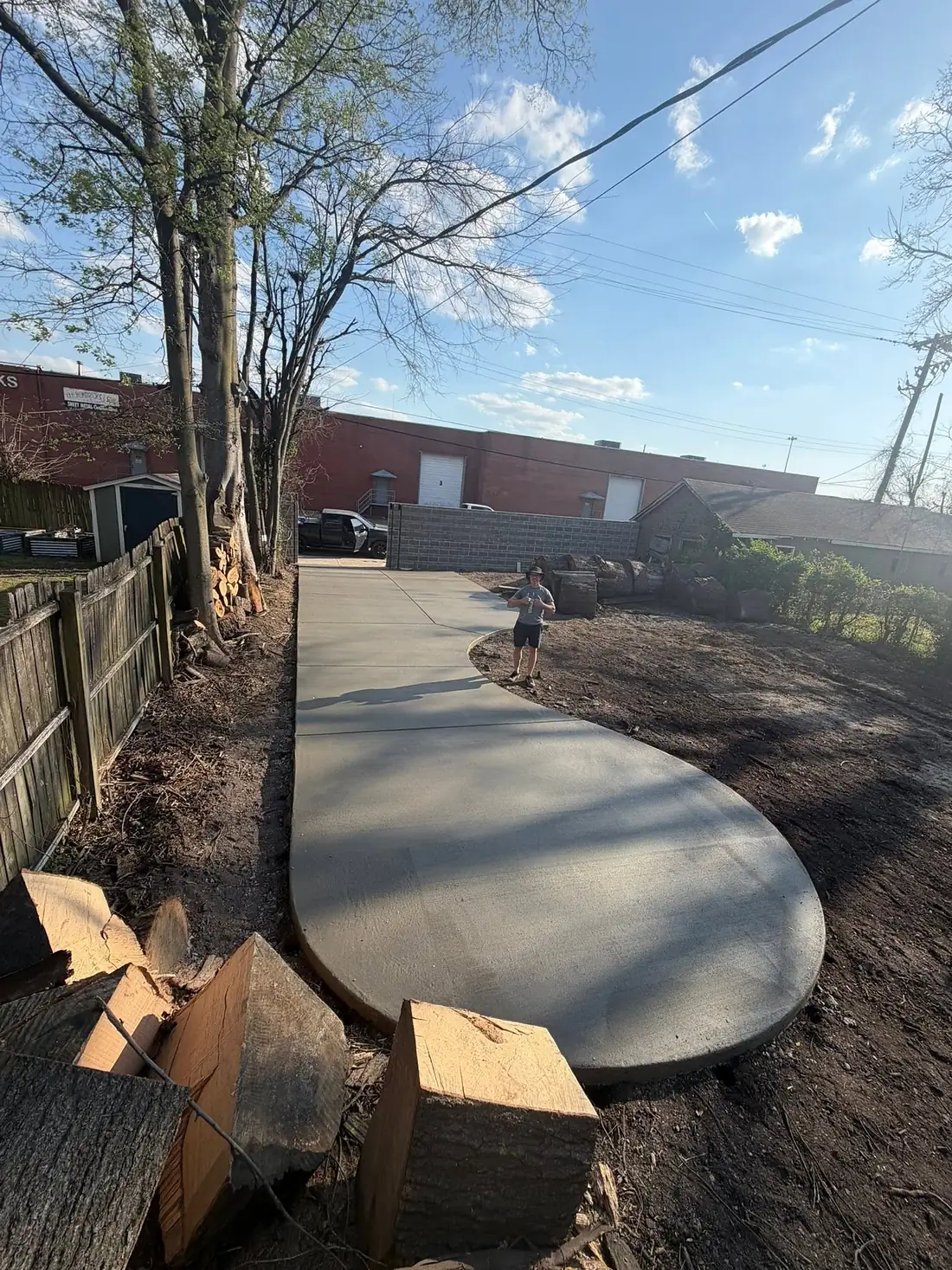 Wide curved concrete pad finished with a broom texture