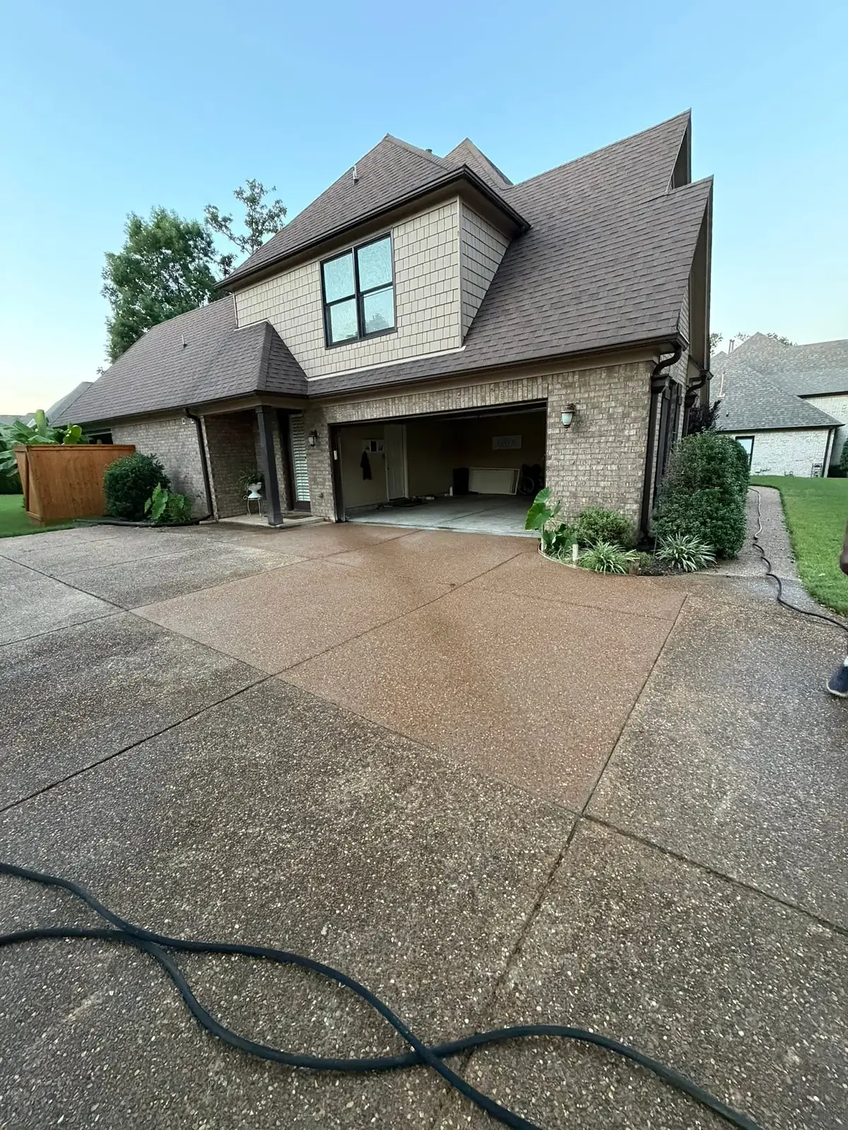 Finished wash finish concrete driveway in front of a large brick home