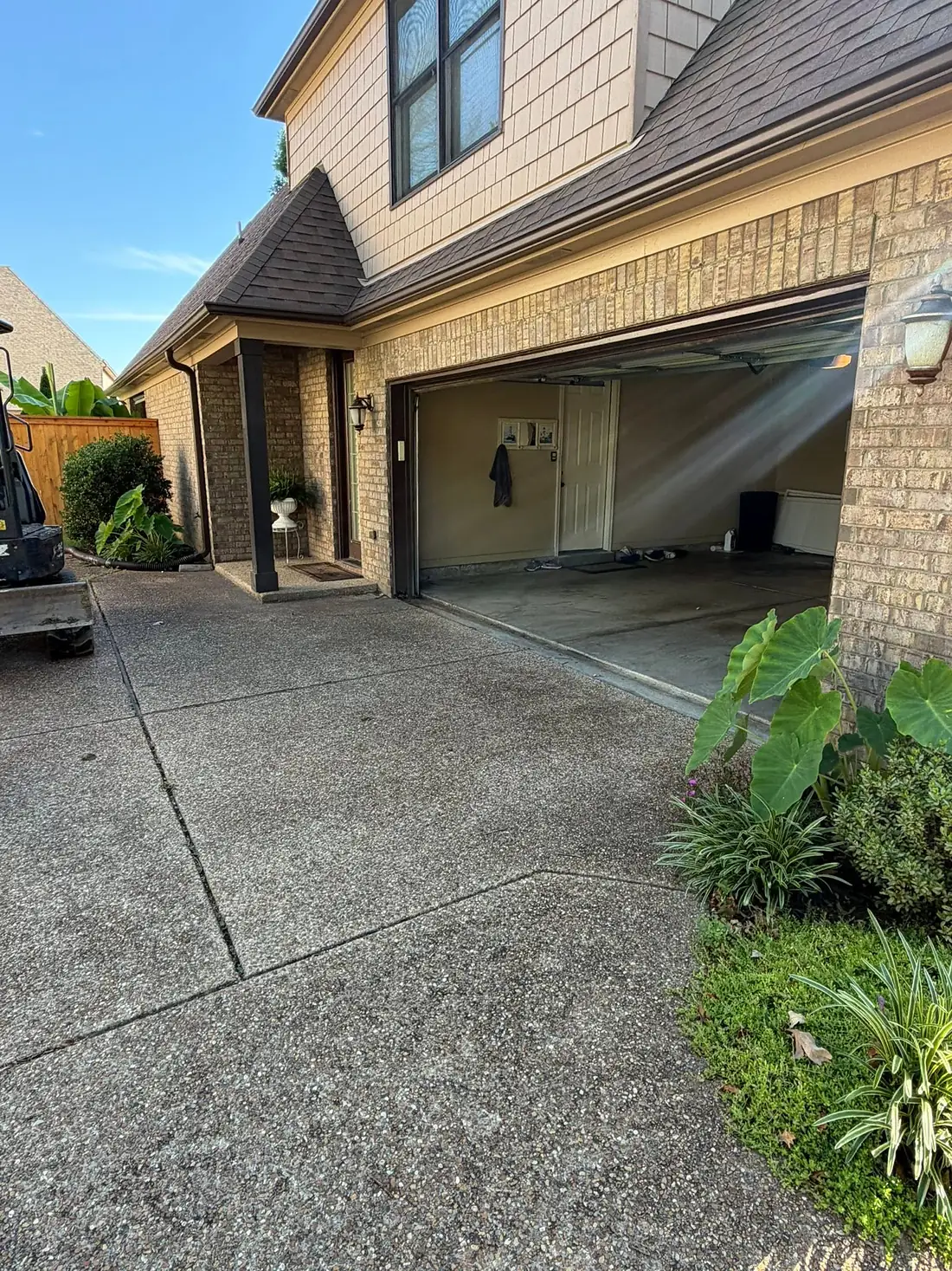 Concrete driveway apron meeting a garage door after replacement