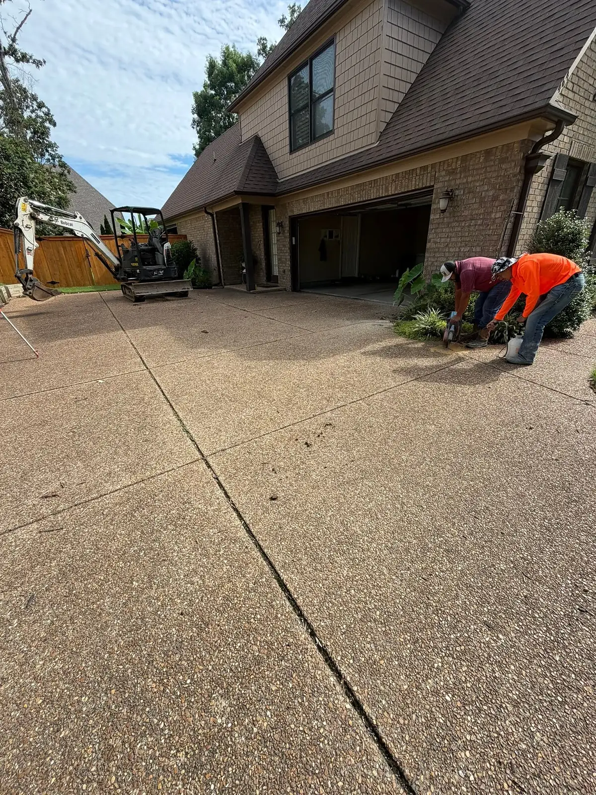 KRS Concrete worker washing the surface of a fresh exposed aggregate driveway