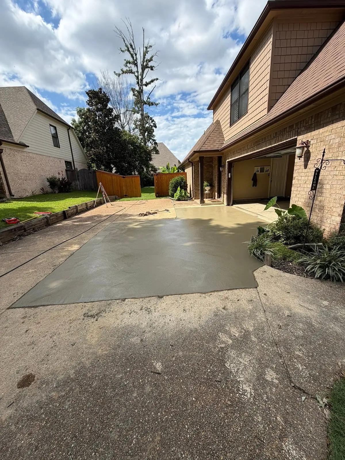 Freshly poured concrete driveway extension still wet and grey