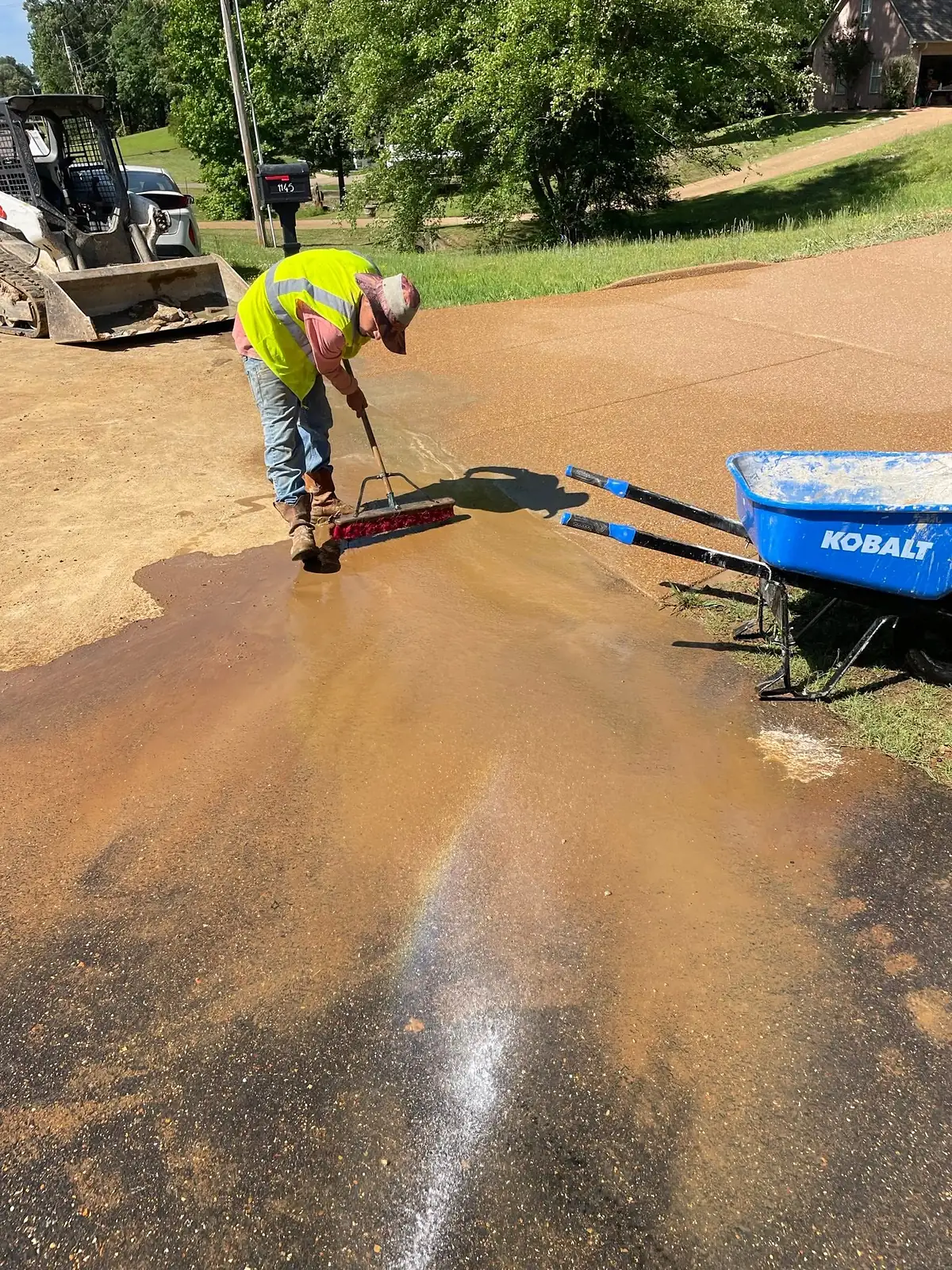 Worker washing the cement paste off to expose the aggregate finish